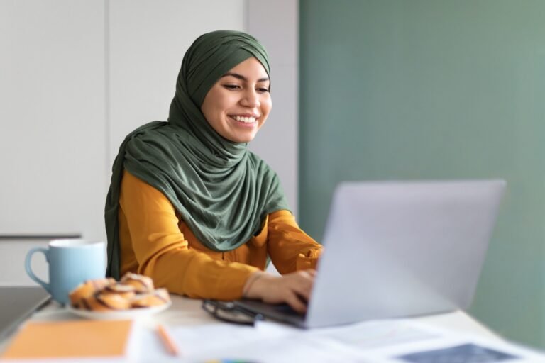 Online Education. Smiling Young Muslim Woman In Hijab Using Laptop At Home
