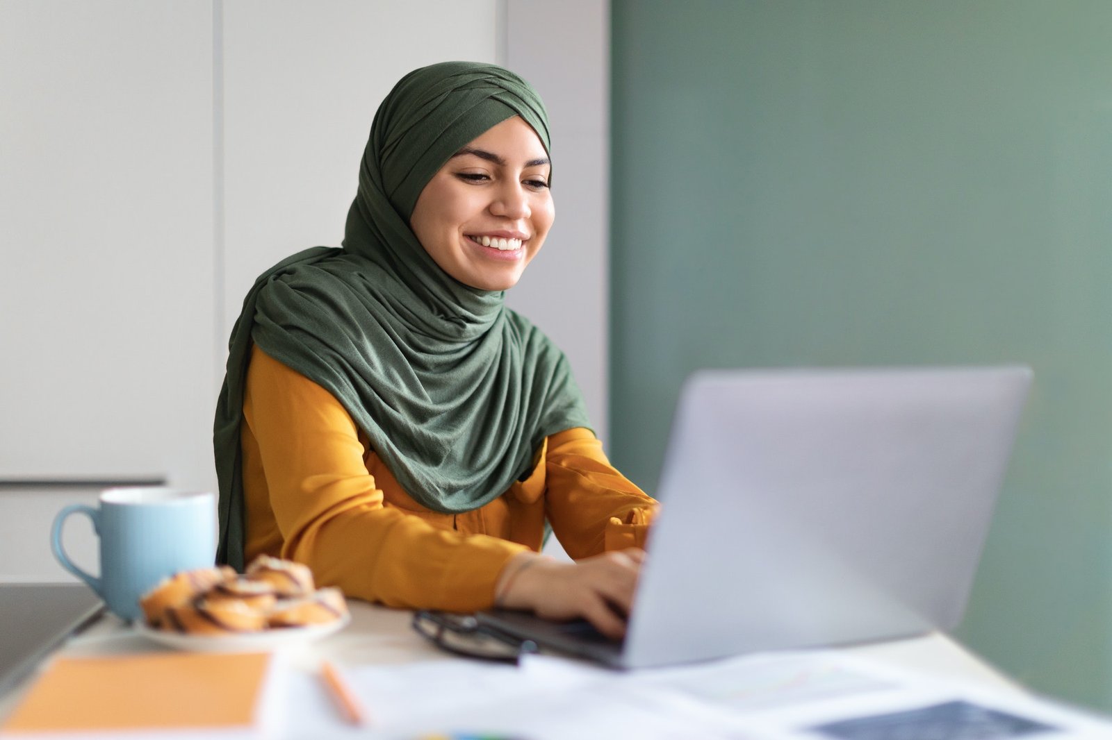 Online Education. Smiling Young Muslim Woman In Hijab Using Laptop At Home